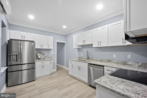 a kitchen with a refrigerator sink and cabinets