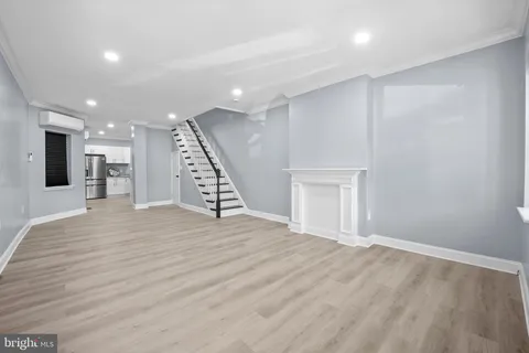a view of a livingroom with an empty space wooden floor and staircase