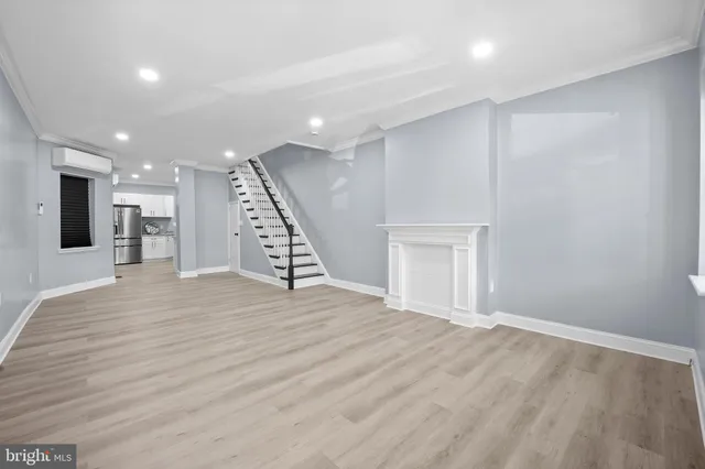 a view of a livingroom with an empty space wooden floor and staircase
