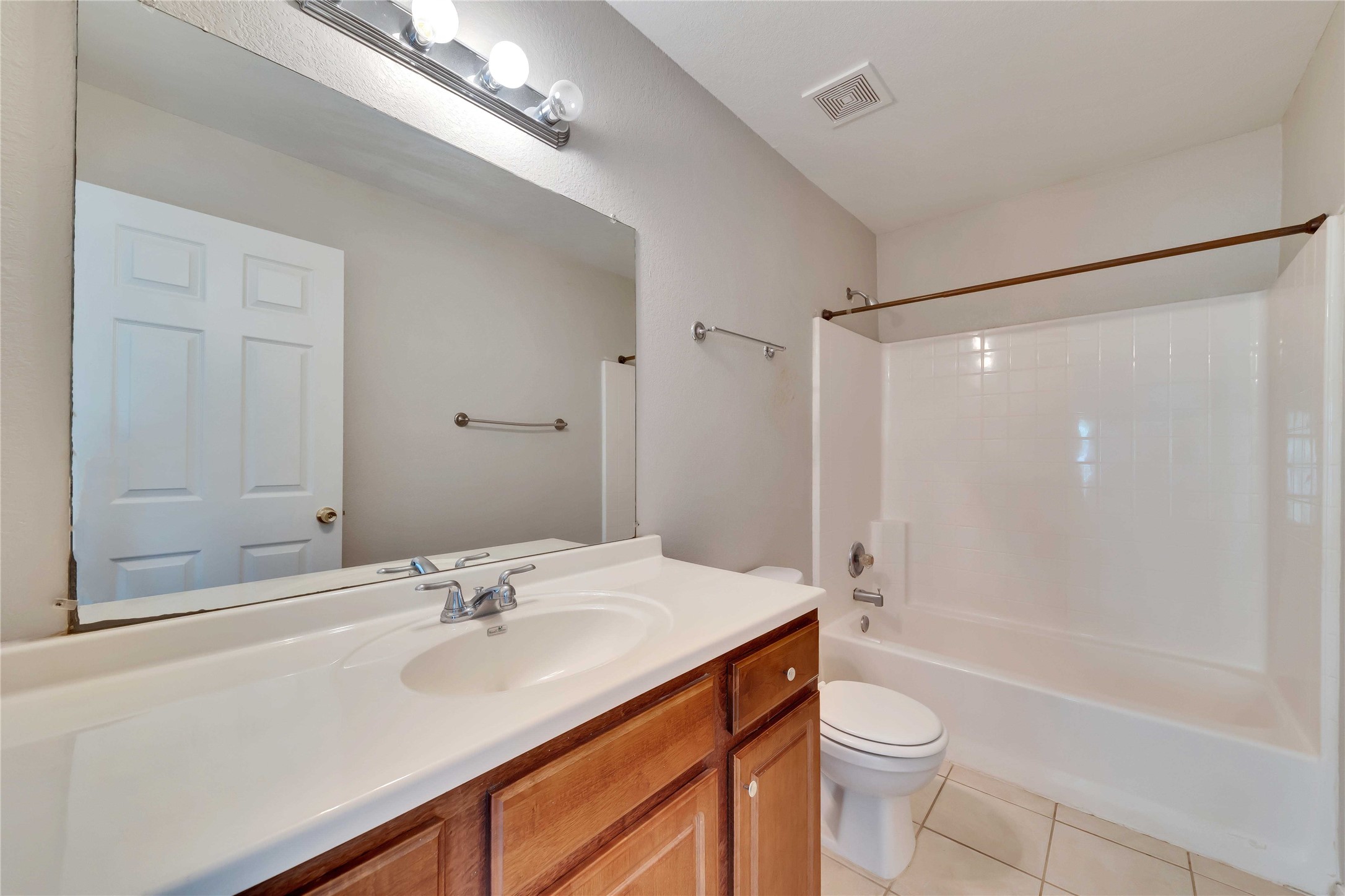2201 East 18th Street, Unit B Austin, TX 78702 - Photo 18 of 25 A well-maintained bathroom with a spacious vanity, large mirror, and full shower-tub combination.
