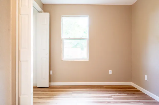 a view of a small space with wooden floor and a window