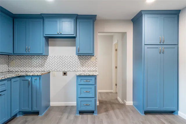 a kitchen with granite countertop wooden cabinets and white appliances