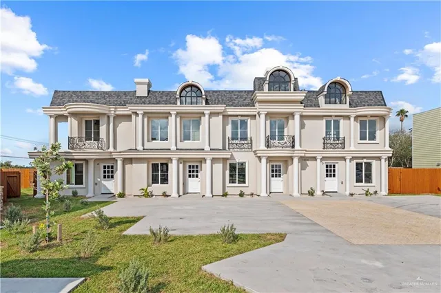 a front view of a residential apartment building with a yard