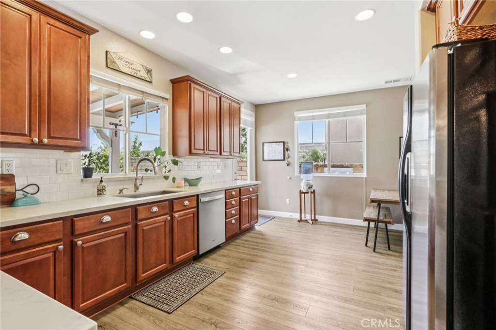 19941 Christopher Lane Saugus, CA 91350 - Photo 17 of 34 a kitchen with stainless steel appliances granite countertop a refrigerator a sink dishwasher a stove and white countertops with wooden floor