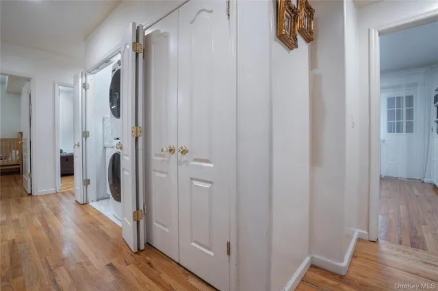 a view of a hallway with wooden floor and closet area