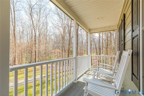 a view of a porch with wooden floor and furniture