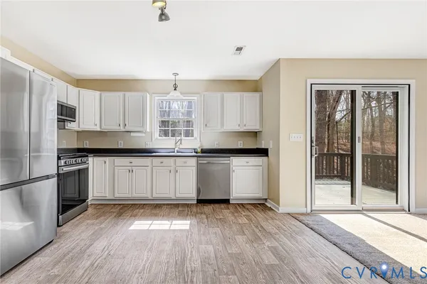 a kitchen with granite countertop a sink cabinets and stainless steel appliances