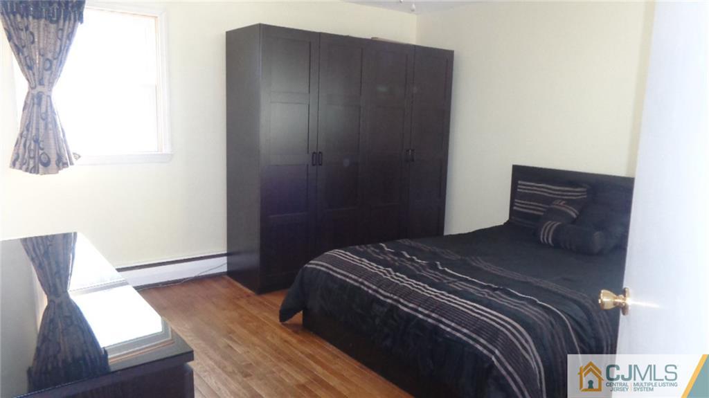 34 Brandywine Road Fords, NJ 08863 - Photo 10 of 19 a bed sitting in a bedroom next to a window with wooden floor