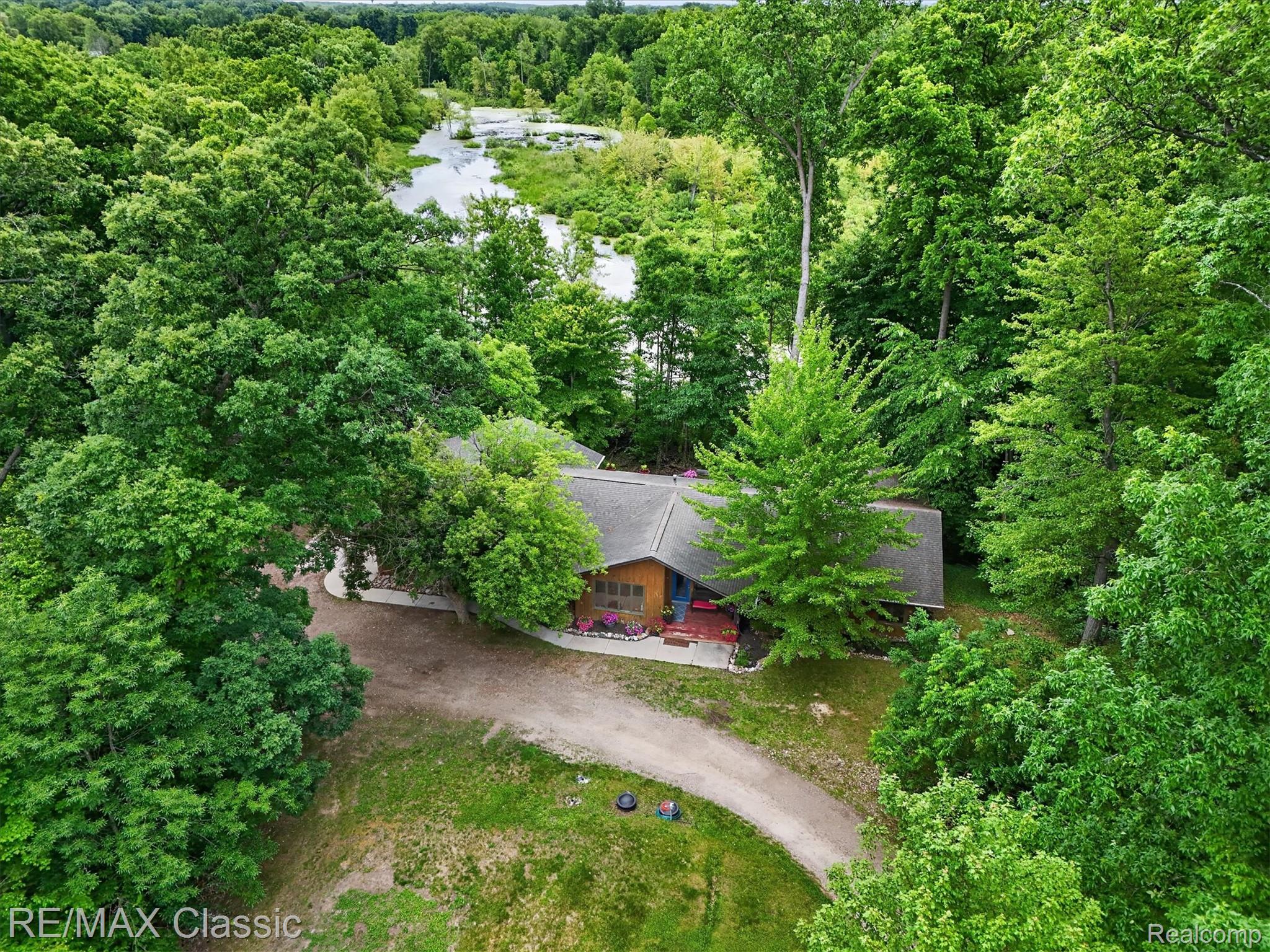 12189 Gage Road Holly, MI 48442 - Photo 56 of 69 Wooded property with a single-story residence and a gravel driveway