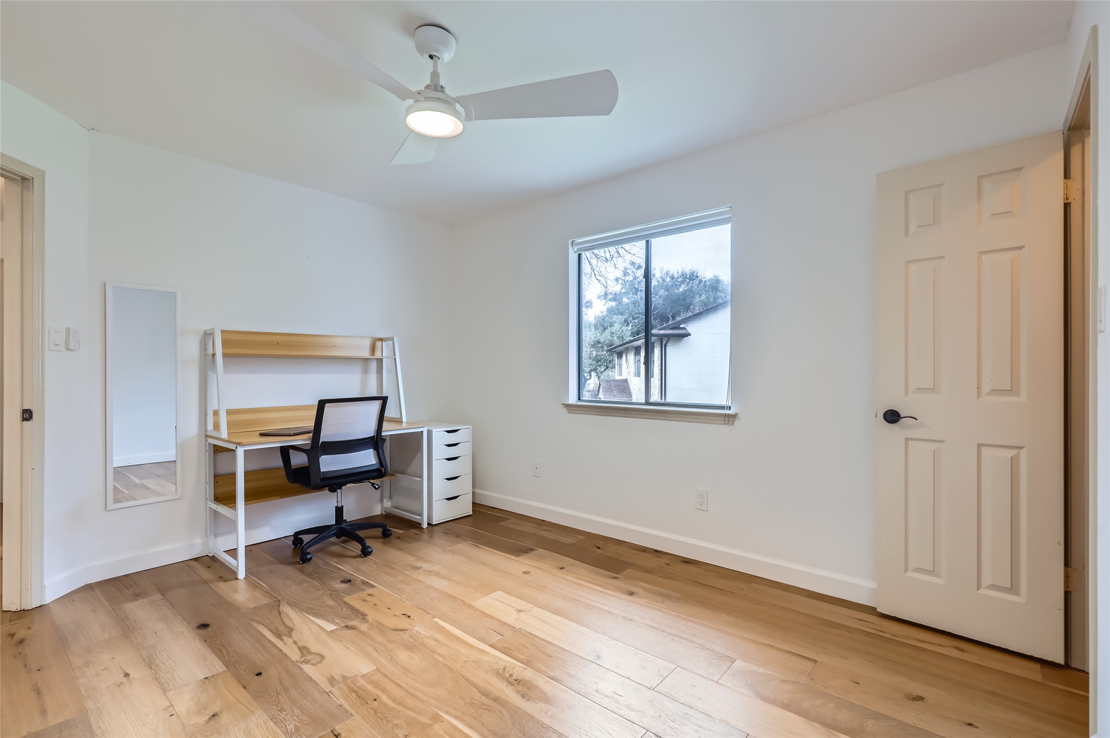 13205 Kepler Cove Austin, TX 78729 - Photo 23 of 34 Room featuring light wood-finish flooring, white walls, and a contemporary ceiling fan with integrated lighting