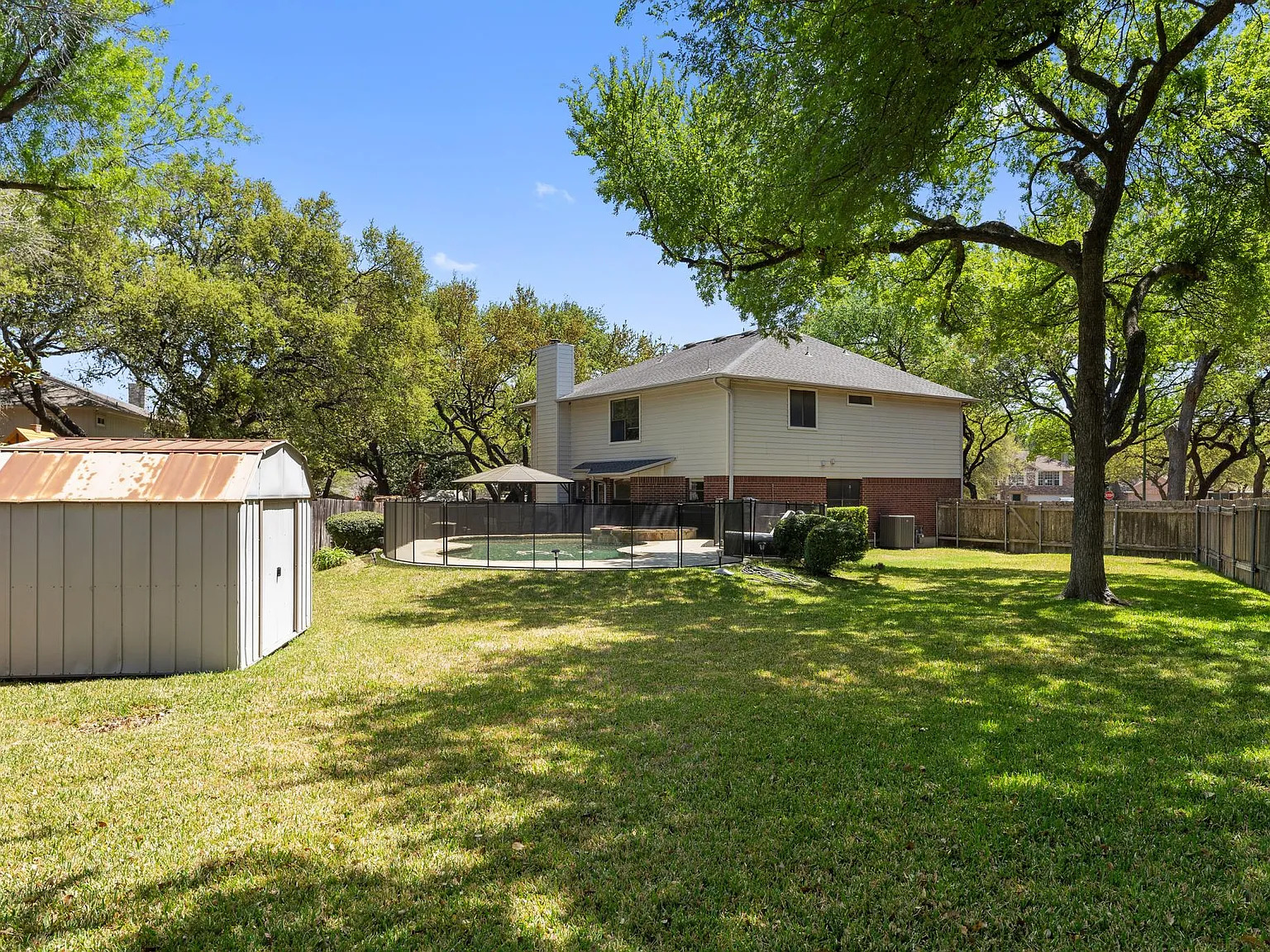 13205 Kepler Cove Austin, TX 78729 - Photo 31 of 34 a backyard of a house with table and chairs under an umbrella
