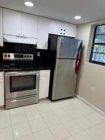 a kitchen with a refrigerator sink and cabinets
