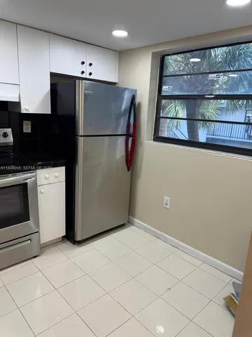 a kitchen with a refrigerator and a stove top oven
