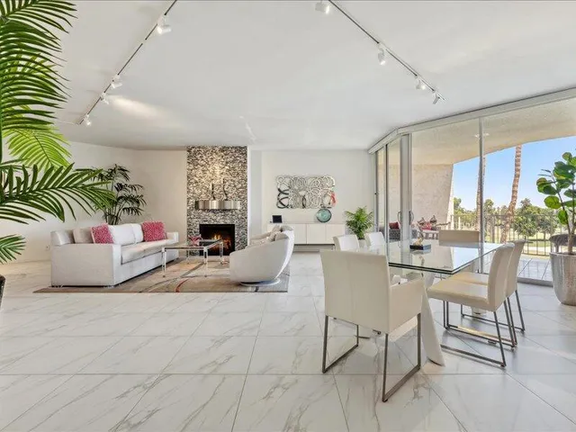 a living room with fireplace furniture and a large window