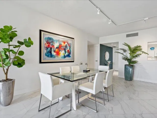 a dining room with furniture and a potted plant