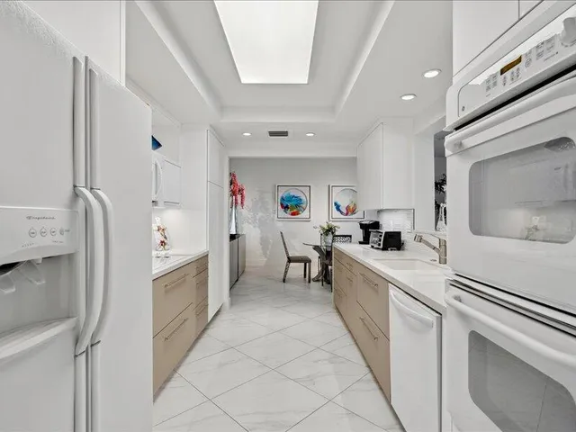 a kitchen with white cabinets and white appliances