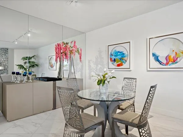 a view of a dining room with furniture a kitchen and chandelier