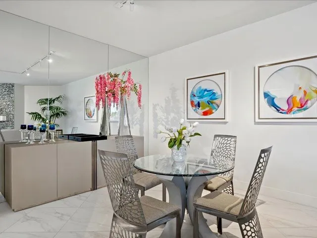 a view of a dining room with furniture a kitchen and chandelier