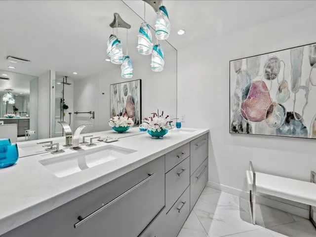 a bathroom with a sink a mirror and a painting on the wall