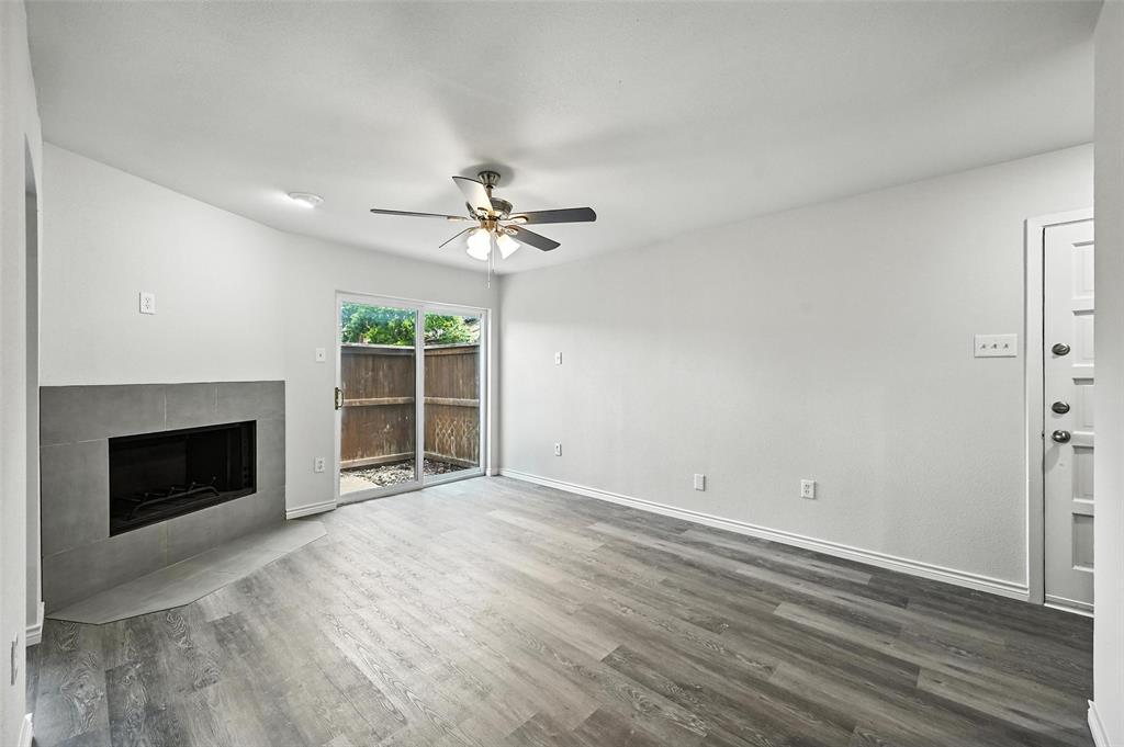 5626 Preston Oaks Road, Unit 22C Dallas, TX 75254 - Photo 11 of 29 a view of an empty room with wooden floor fireplace and a window