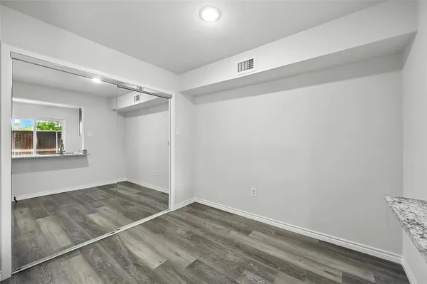 an empty room with windows and closet