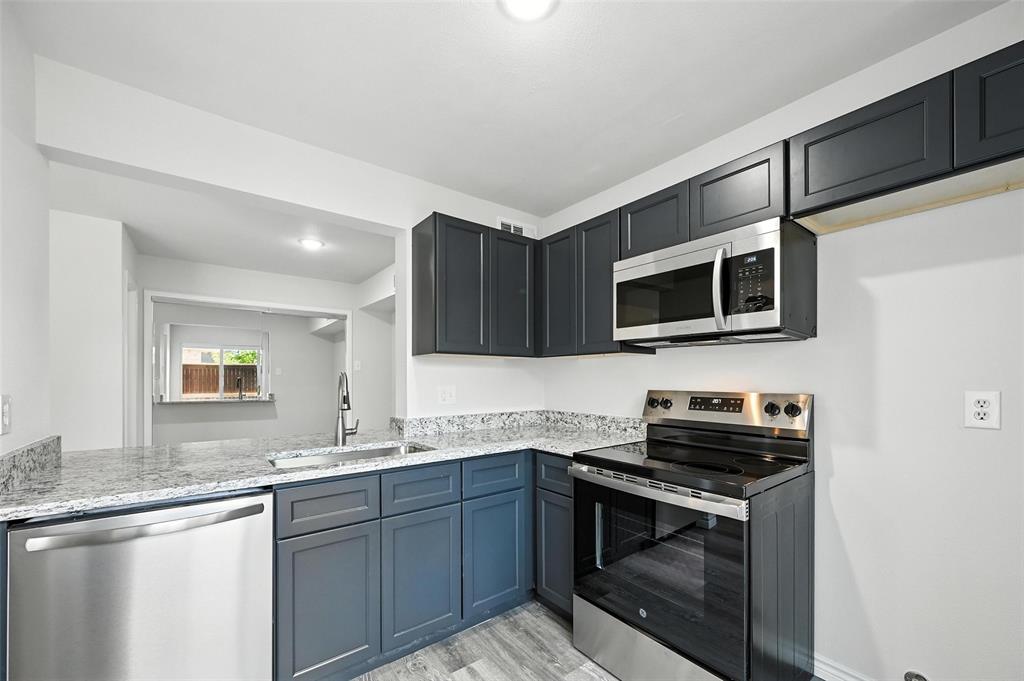 5626 Preston Oaks Road, Unit 22C Dallas, TX 75254 - Photo 17 of 29 a kitchen with stainless steel appliances a stove microwave and sink
