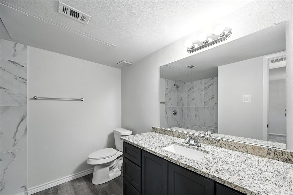 5626 Preston Oaks Road, Unit 22C Dallas, TX 75254 - Photo 24 of 29 a bathroom with a granite countertop sink a toilet and a shower