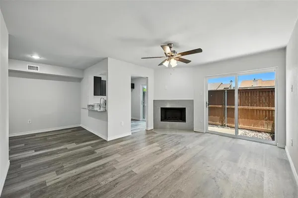 a view of an empty room with a fireplace and a window