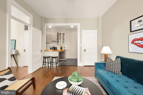 a living room with furniture a rug and a lamp