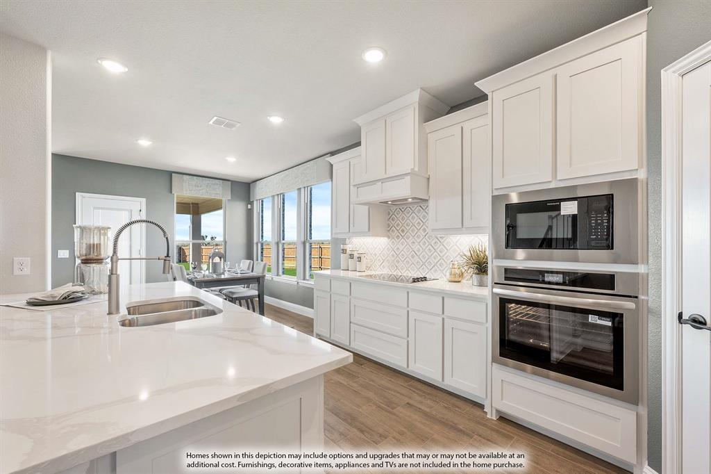5418 Rutherford Drive Midlothian, TX 76065 - Photo 9 of 40 a kitchen with kitchen island a stove a sink and a microwave