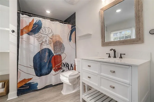 a bathroom with a sink a toilet and shower