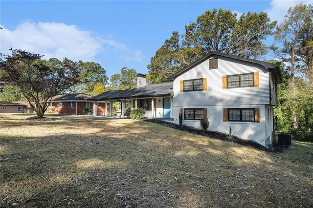 a front view of house with yard and trees in the background