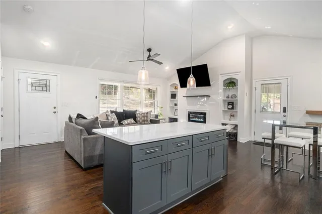 a view of living room with kitchen island furniture and flat screen tv