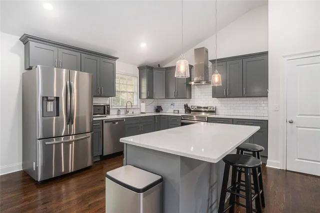 a kitchen with kitchen island a sink appliances and cabinets