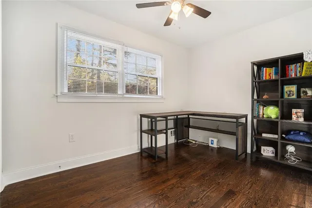a view of an empty room with workspace and wooden floor