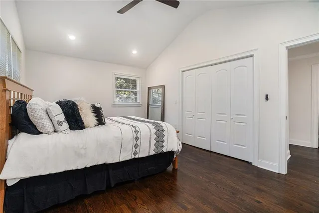 a spacious bedroom with a bed and wooden floor