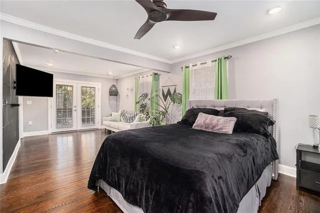 a spacious bedroom with a large bed and a flat tv screen on dresser