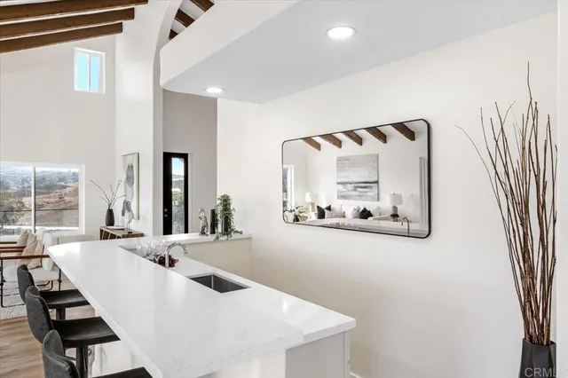 a large kitchen with granite countertop a stove a sink a dining table and chairs with wooden floor