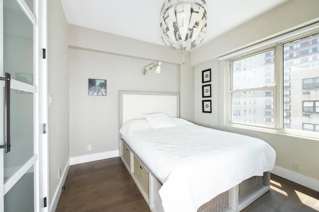 a living room with furniture a flat screen tv and a window