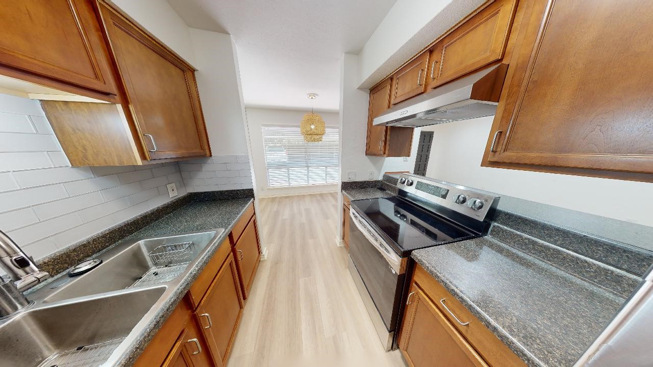 500 East Riverside Drive, Unit 132 Austin, TX 78704 - Photo 5 of 18 a kitchen with wooden cabinets and a stove top oven