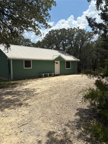 a front view of house with yard and trees around