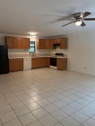 a large kitchen with stainless steel appliances a sink and cabinets