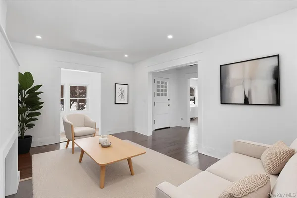 a living room with furniture a potted plant and wooden floor