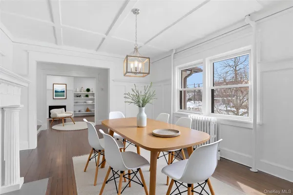a dining room with furniture a chandelier and wooden floor