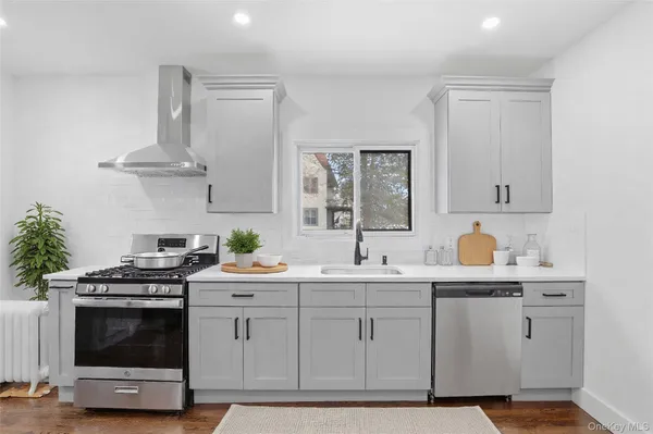 a kitchen with stainless steel appliances a sink stove and cabinets