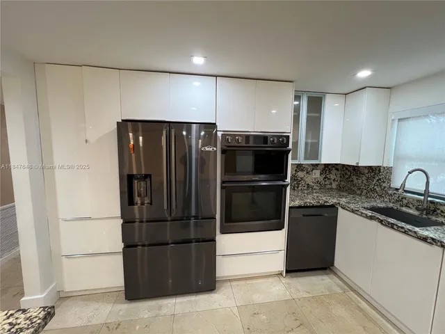 a kitchen with stainless steel appliances granite countertop a refrigerator and a sink