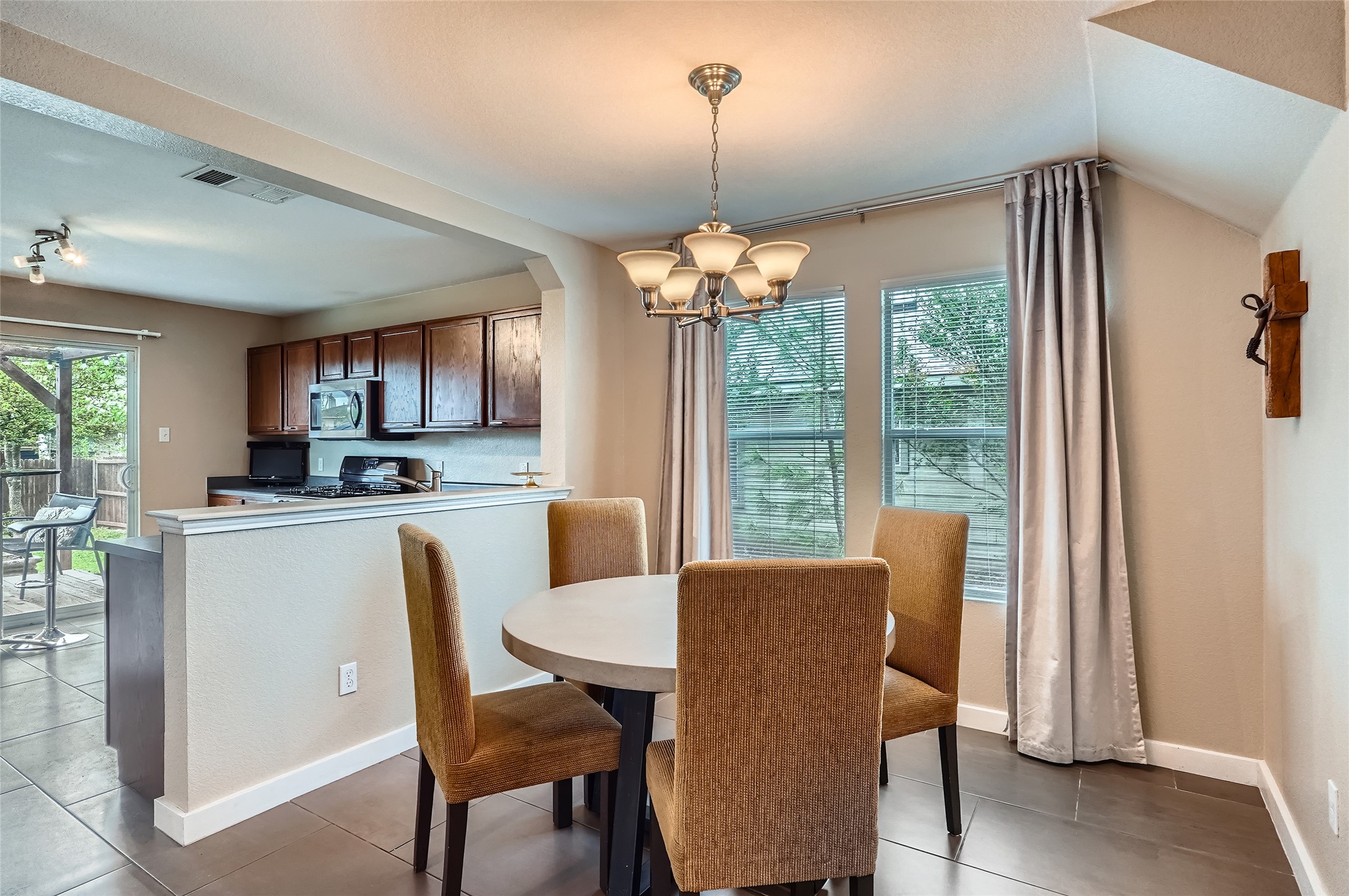 18021 Prairie Verbena Lane Elgin, TX 78621 - Photo 6 of 33 A well-lit dining area featuring a contemporary chandelier and easy kitchen access.