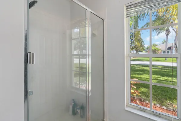 a bathroom with a glass door and a window