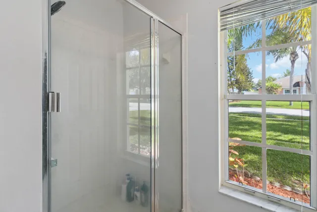 a bathroom with a glass door and a window