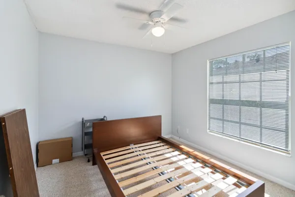 a bedroom with a bed and a large window